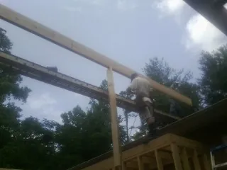 Carpenter setting a ridge beam over a new addition frame — Ice Dam Removal by Roofing Brothers in Beaver Dams
