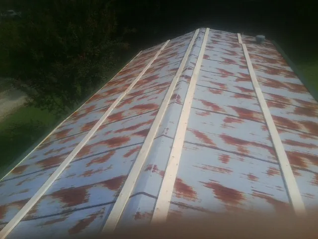 Rusted metal roof panels with new wood purlins before replacement — Storm Damage Roof Repair in Beaver Dams by Roofing Brothers